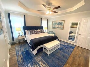Relax in this stylish room with a large bed, bedside table, and ceiling fan.