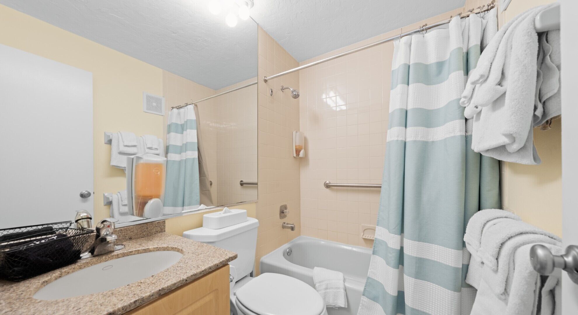 Un baño con ducha, inodoro, lavabo y espejo.