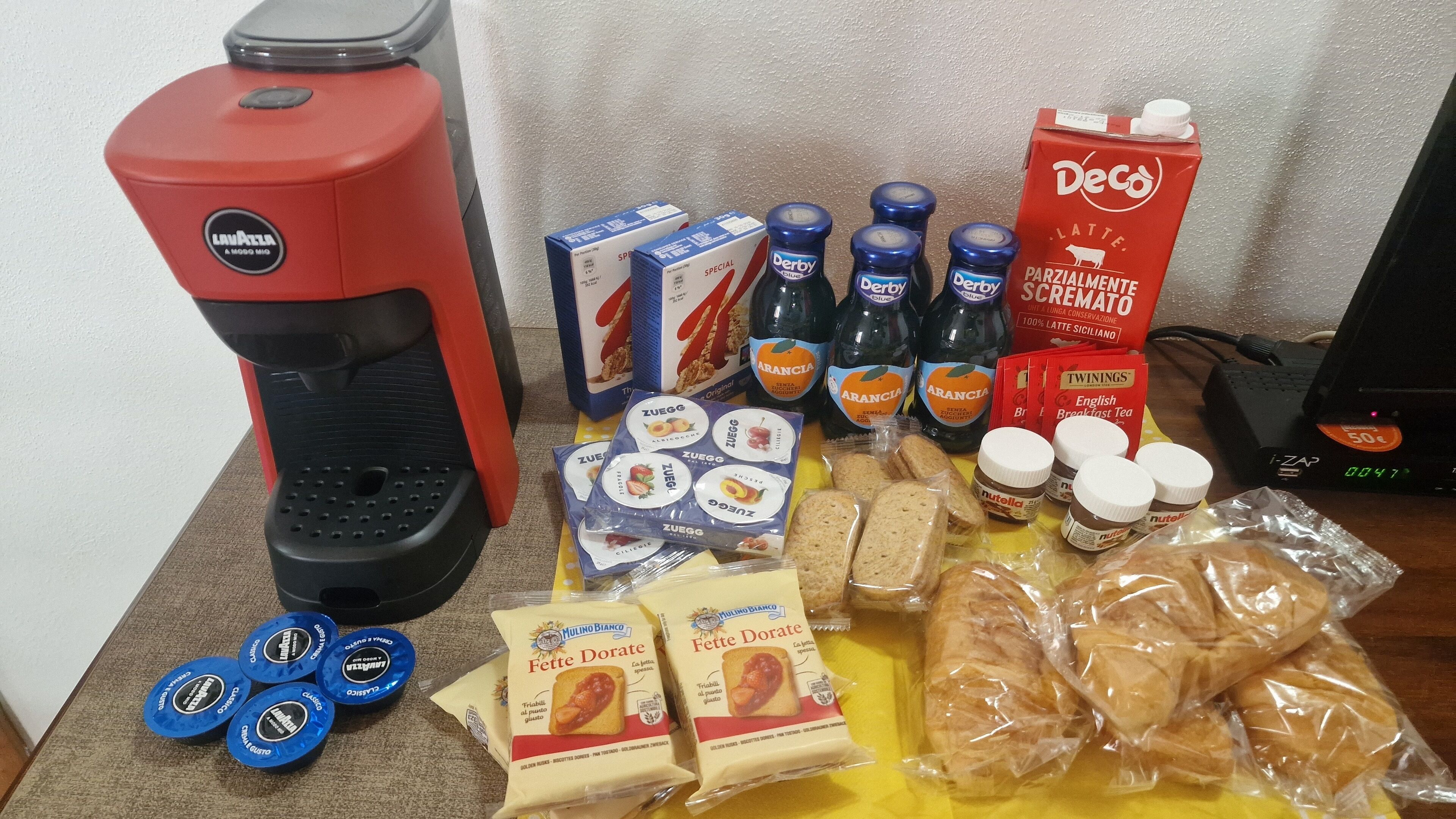 A variety of food items and a coffee machine on a table.