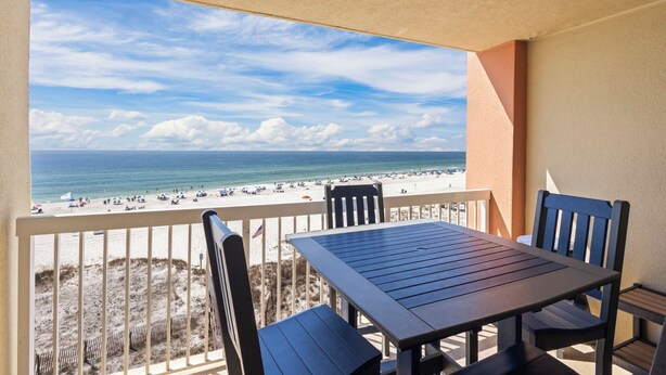 Un balcon avec vue sur une plage et l’océan.