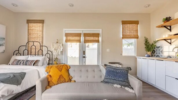 Ein modernes Schlafzimmer mit Bett, Sofa und Blick ins Freie.
