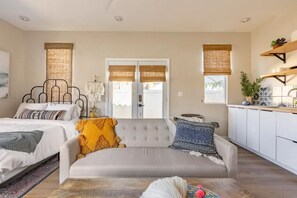 Une chambre moderne avec un lit, un canapé et une vue sur l’extérieur.