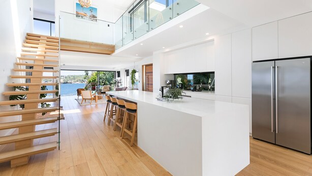 A modern kitchen with a large island, stainless steel appliances, and a view of the sea. - 6 bedrooms, ocean views, pool & spa (Cronulla)