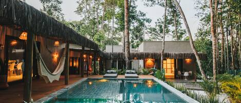 Una piscina al aire libre, sillones reclinables de piscina