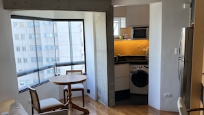 Een modern appartement met een woonkamer, eethoek en keuken.