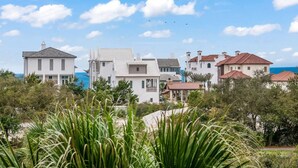 A coastal residential area with multiple houses, some with red-tiled roofs and others with white exteriors. - Whispering Palms Seacrest (Panama City Beach)