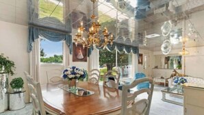 Uma sala de jantar com uma mesa de madeira, cadeiras e um candelabro.
