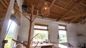 A rustic interior with a wooden ceiling, a dining table with a glass jar and a kettle, and a hanging light fixture. - Buen Camino Hotel, San Mateo (San Mateo)