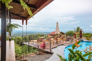 Ein Poolbereich mit Liegestühlen und Blick auf die Landschaft.