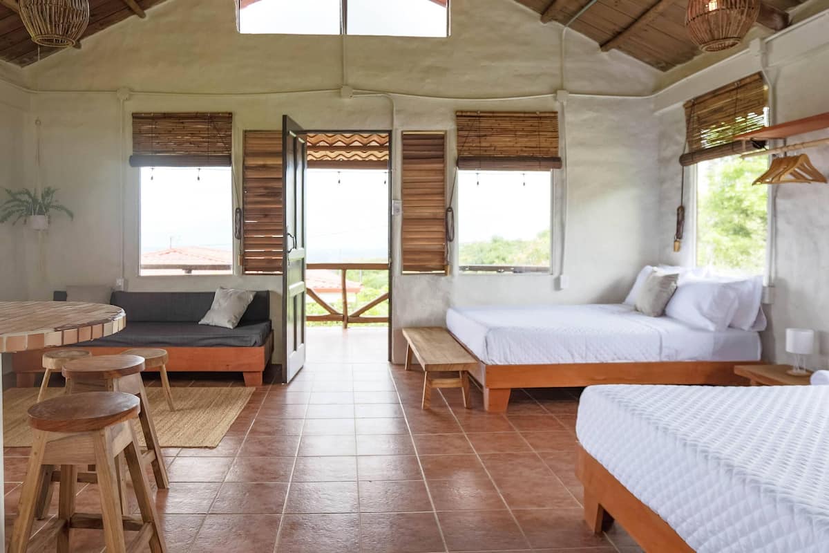 Una habitación acogedora con una cama, un sofá, una mesa de comedor y una pequeña cocina.