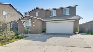 A two-story house with a garage, a covered entryway, and a landscaped front yard. - Pool Table & Patio! Spacious Merced Getaway (Merced)