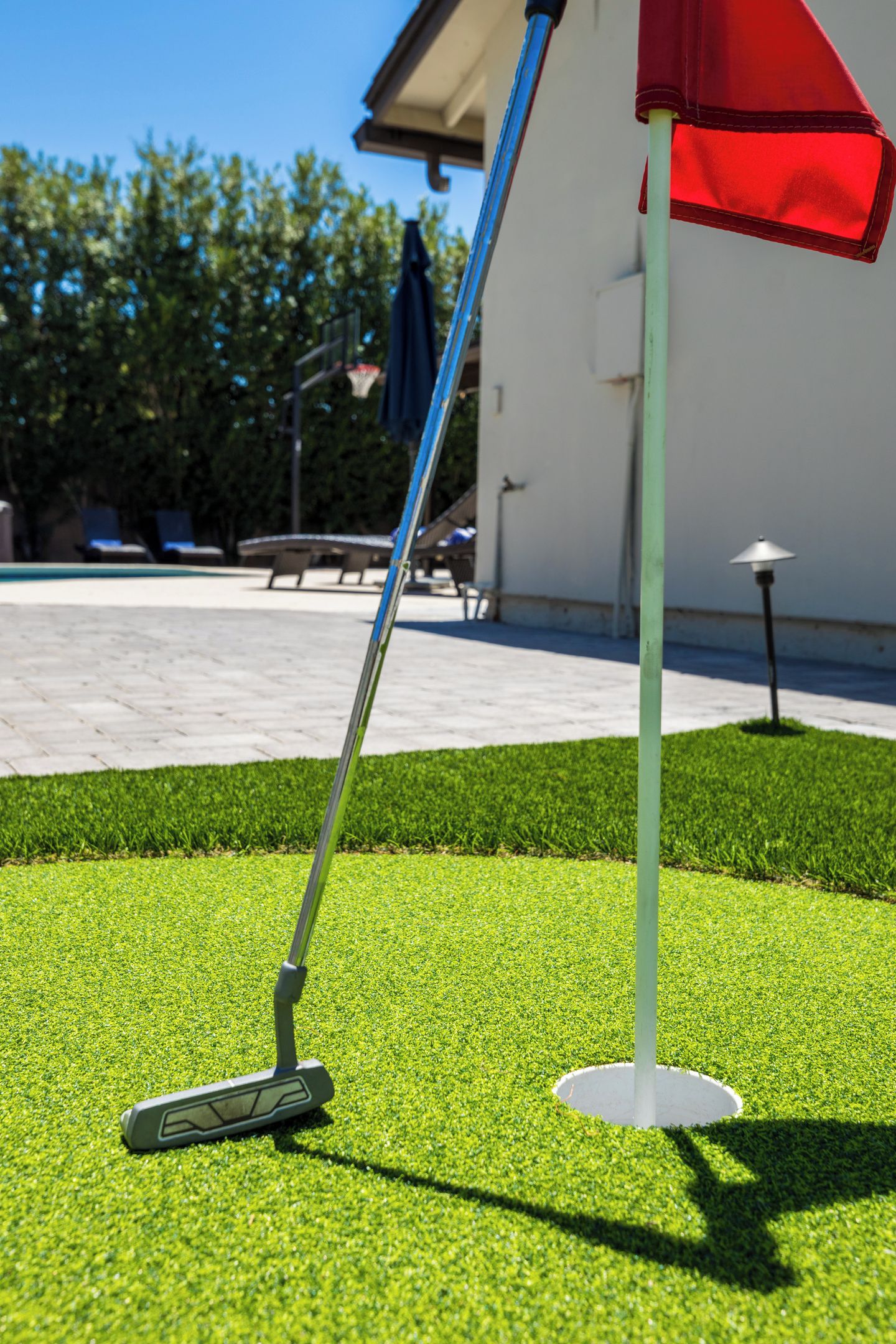 Een golfclub op kunstgras, met een rode luifel in de buurt.