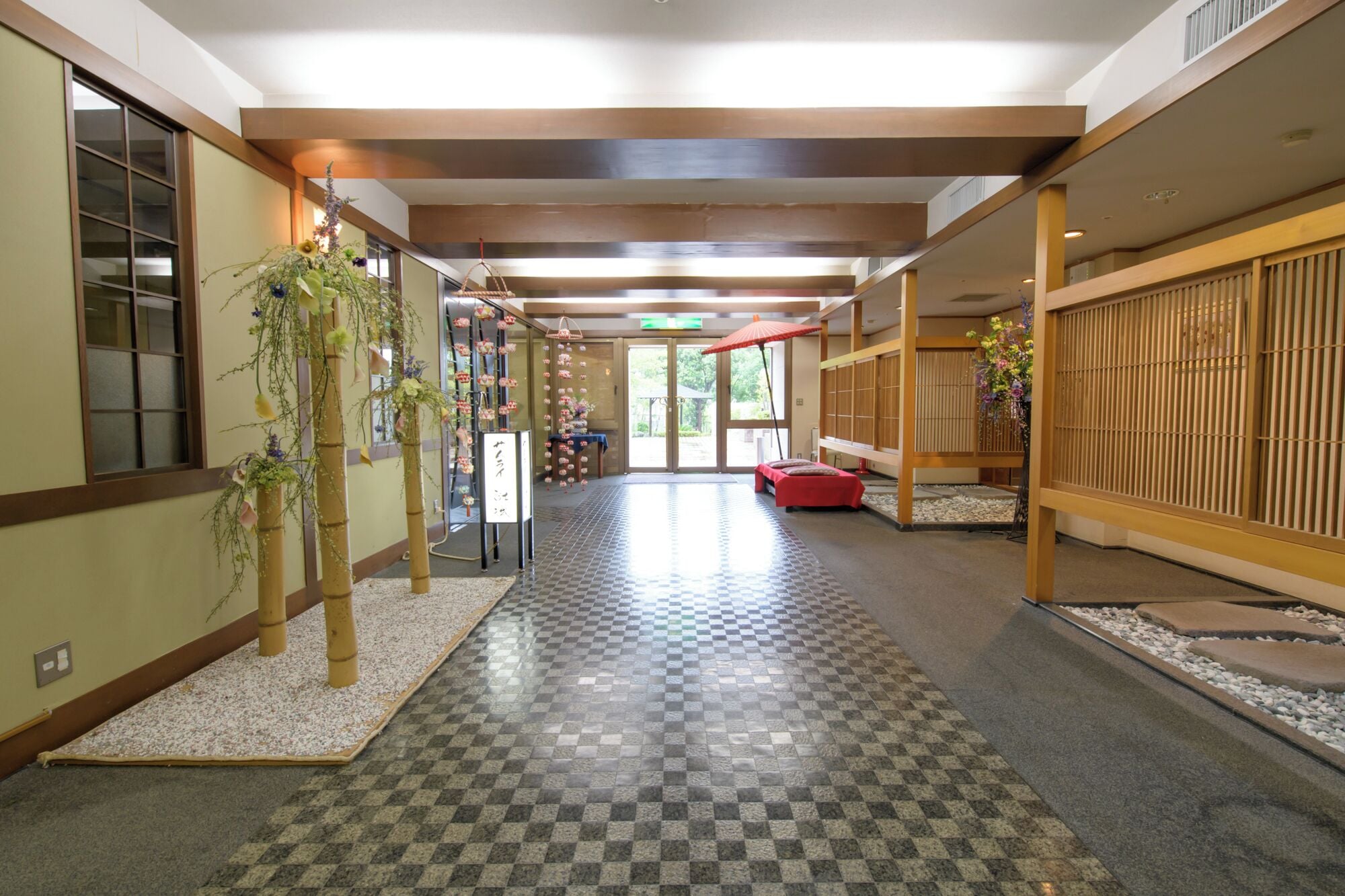 A traditional Japanese interior with tatami flooring, sliding doors, and a reception area with a red bench.