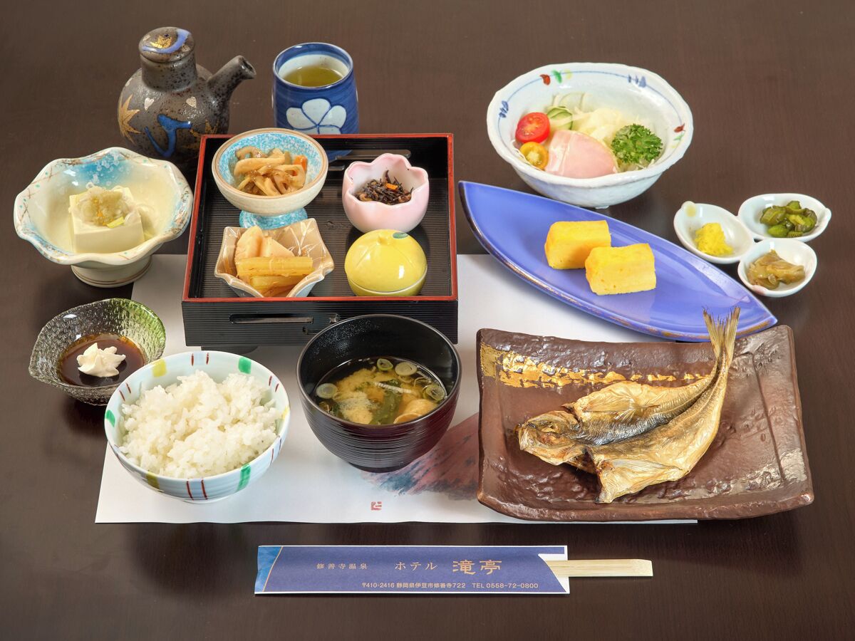 Una comida tradicional japonesa con diversos platos, incluyendo arroz, pescado y encurtidos.