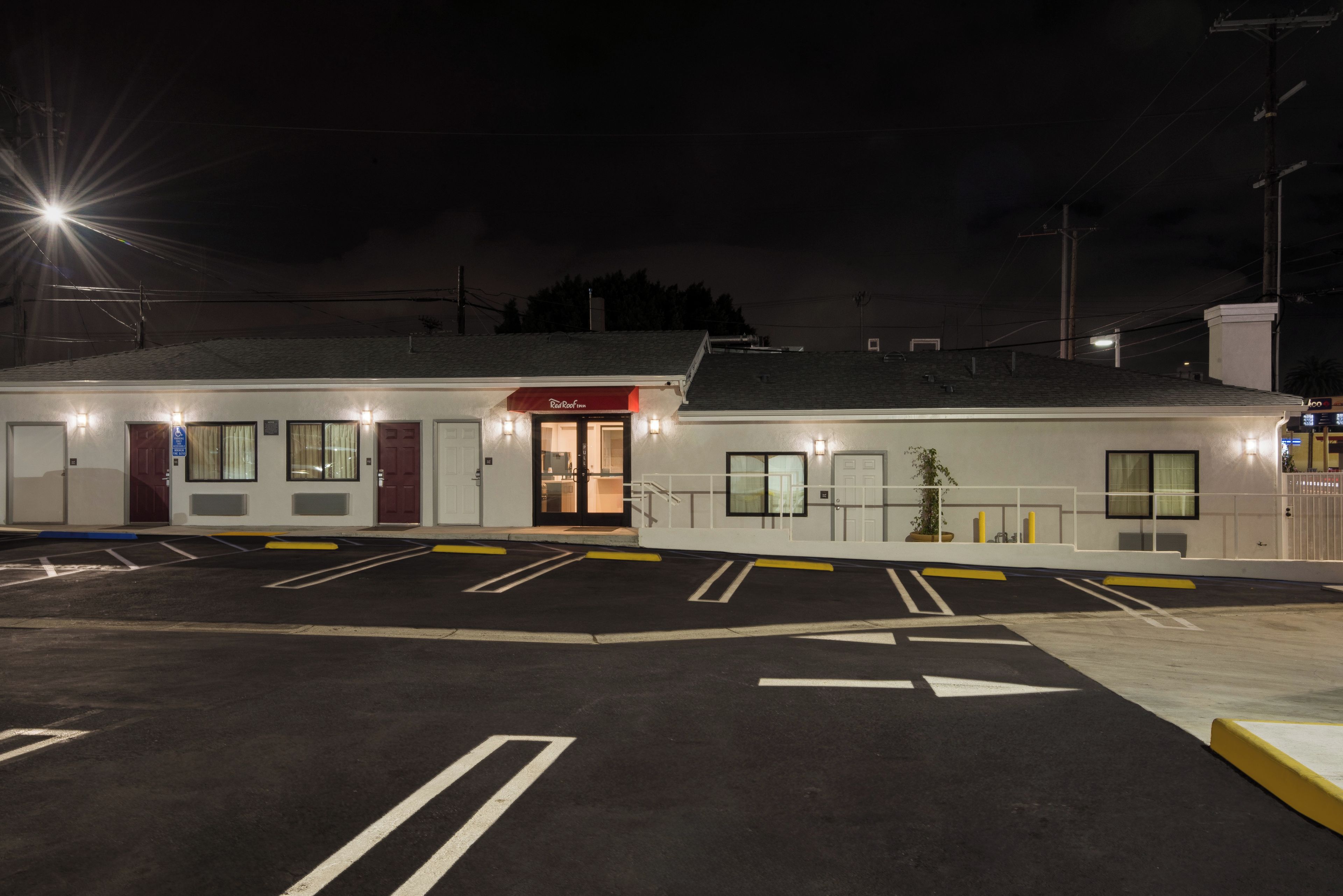 A well-lit hotel with a parking lot, a reception area, and a visible entrance.