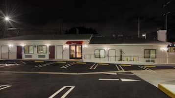A well-lit hotel with a parking lot, a reception area, and a visible entrance.