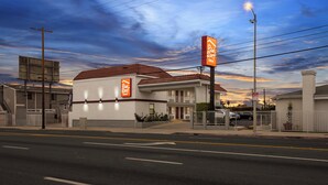 A Red Roof Inn with a red-tiled roof, a white facade, and a signboard. - Red Roof Inn Los Angeles - Wilmington, CA (Wilmington)