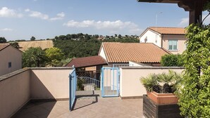 A residential area with a gated entrance, a tiled roof, and a view of a distant hill. - M310 - Marcelli, three-room apartment with terrace convenient to services (Marcelli)