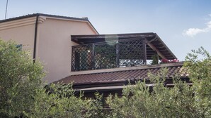 A building with a sloped roof, a balcony with a metal railing, and a clear sky. - M310 - Marcelli, three-room apartment with terrace convenient to services (Marcelli)