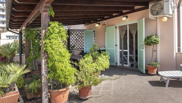 A covered outdoor area with potted plants, a wooden pergola, and a seating area. - M310 - Marcelli, three-room apartment with terrace convenient to services (Marcelli)