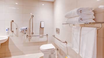 Un baño moderno con inodoro, secamanos y toallero.