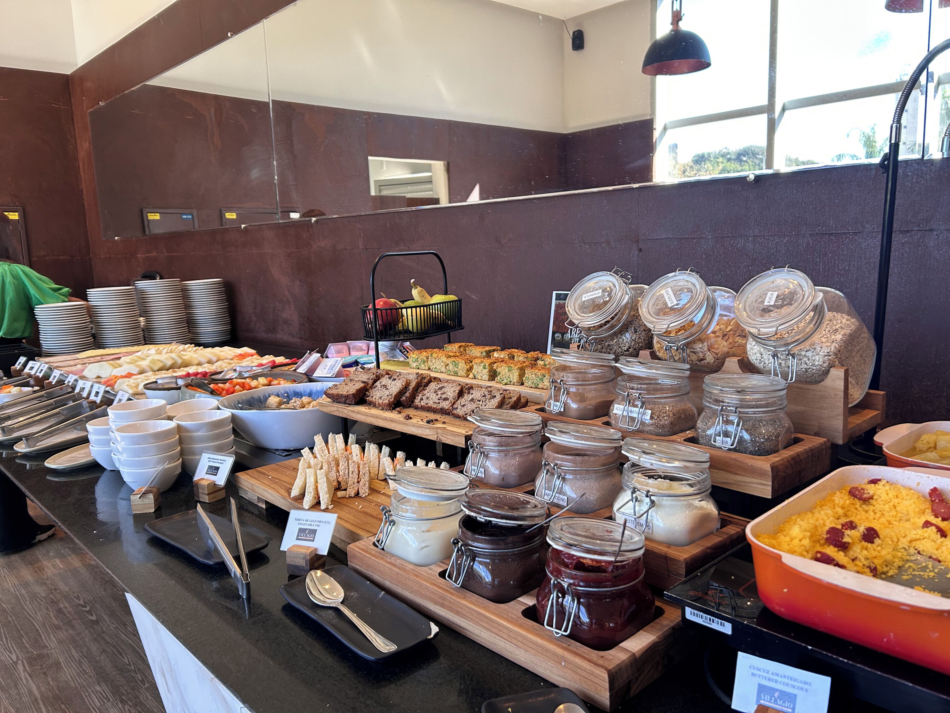 Buffet com diversas opções de comida e acompanhamentos.
