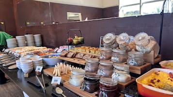 Buffet com diversas opções de comida e acompanhamentos.