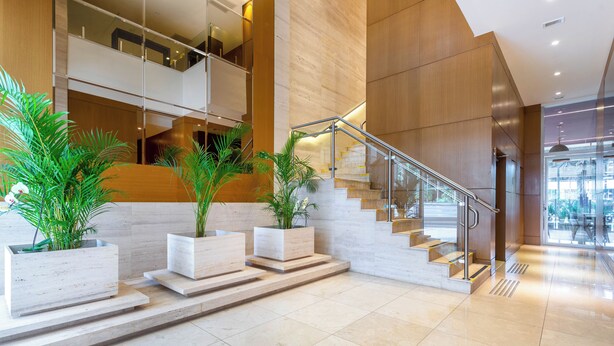 A modern interior with a staircase, potted plants, and a glass railing. - Tryp by Wyndham Brasília Nações (Brasília)
