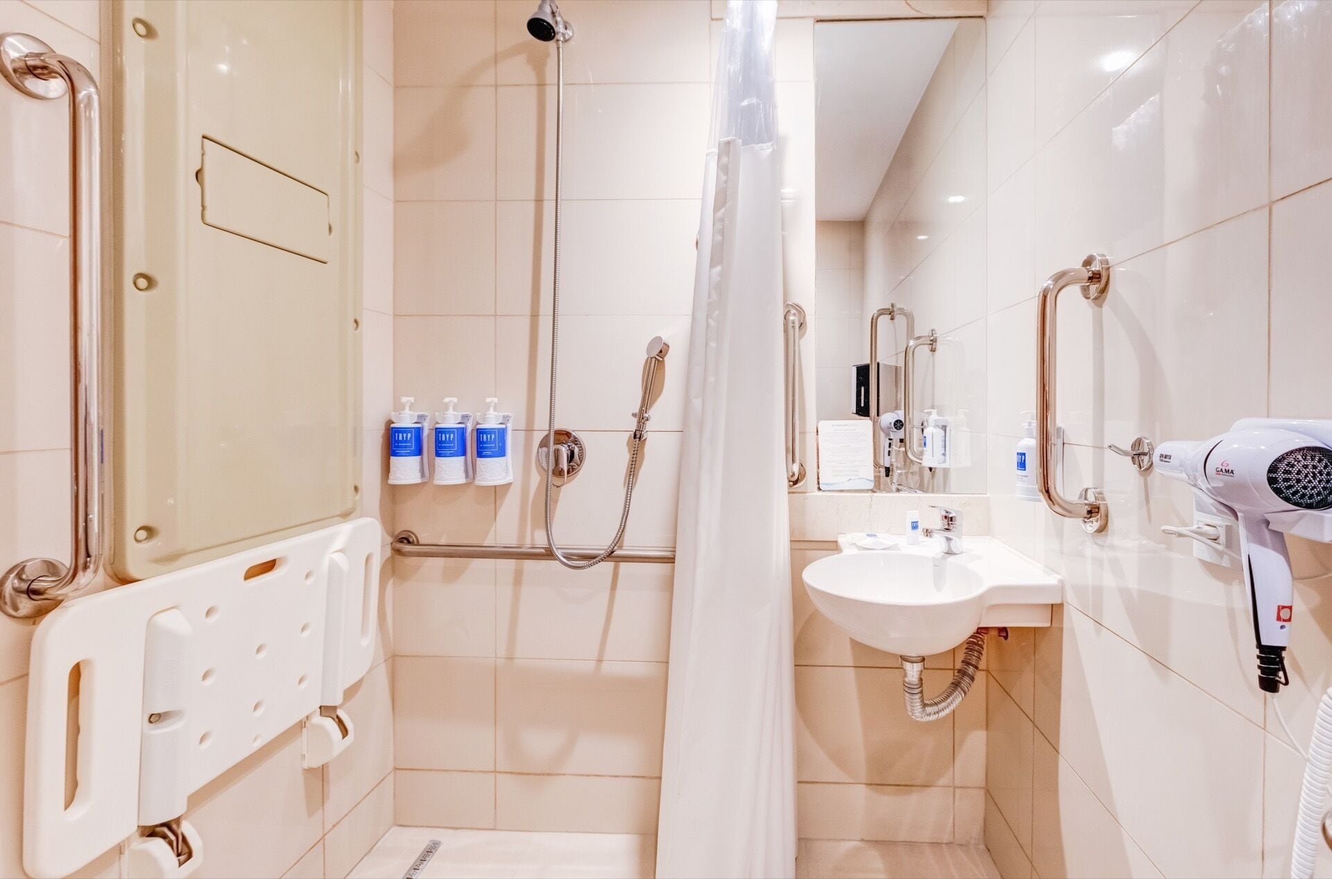 Un baño moderno con cabina de ducha, lavabo y secador de pelo.