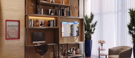 A modern living room with a wooden bookshelf, a flat-screen TV, a desk, and two sofas.