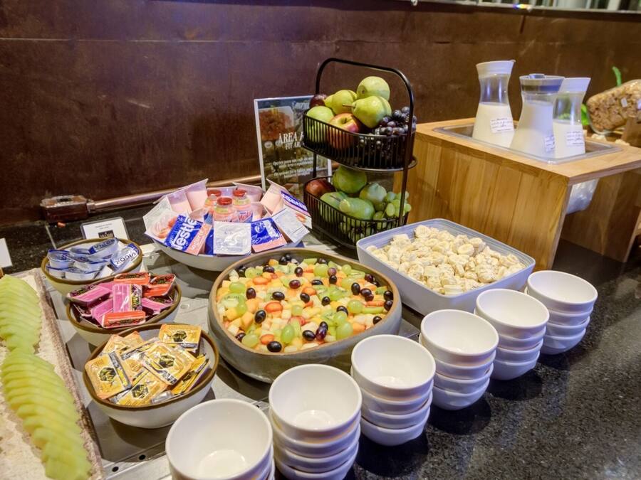 Een buffet met diverse gerechten, waaronder fruit, kazen en verpakte snacks.