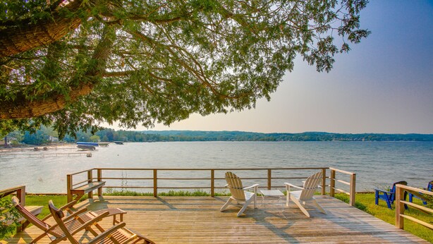 A wooden deck with outdoor seating and a view of a lake. - Waterfront Suttons Bay: Wine Trail, Pickleball Ct (Suttons Bay)