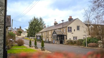 A traditional stone building with a sign for 'Cross Keys Inn' and 'The Cross Keys' pub.
