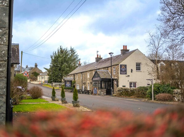 A traditional stone building with a sign for 'Cross Keys Inn' and 'The Cross Keys' pub.