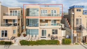A modern two-story building with balconies, large windows, and a flat roof. - Oceanfront Penthouse: Luxury Views, A/C & Parking! (San Diego)