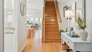 A wooden staircase leading to a dining area with a view of the outdoors. - 110 Waters Edge! Luxury River Views with Community Pool, Screen Porch (Folly Beach)