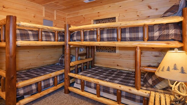 A cabin interior with bunk beds, a lamp, and a window. - Hidden Lake Lodge: Lake + 30 Acres Hocking Hills (Logan)