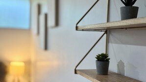 Une étagère fixée au mur, sur laquelle sont posées deux plantes en pot.