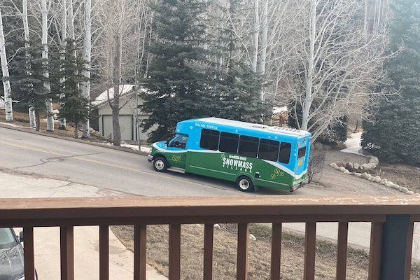 Shuttle bus at end of driveway seen from the deck.