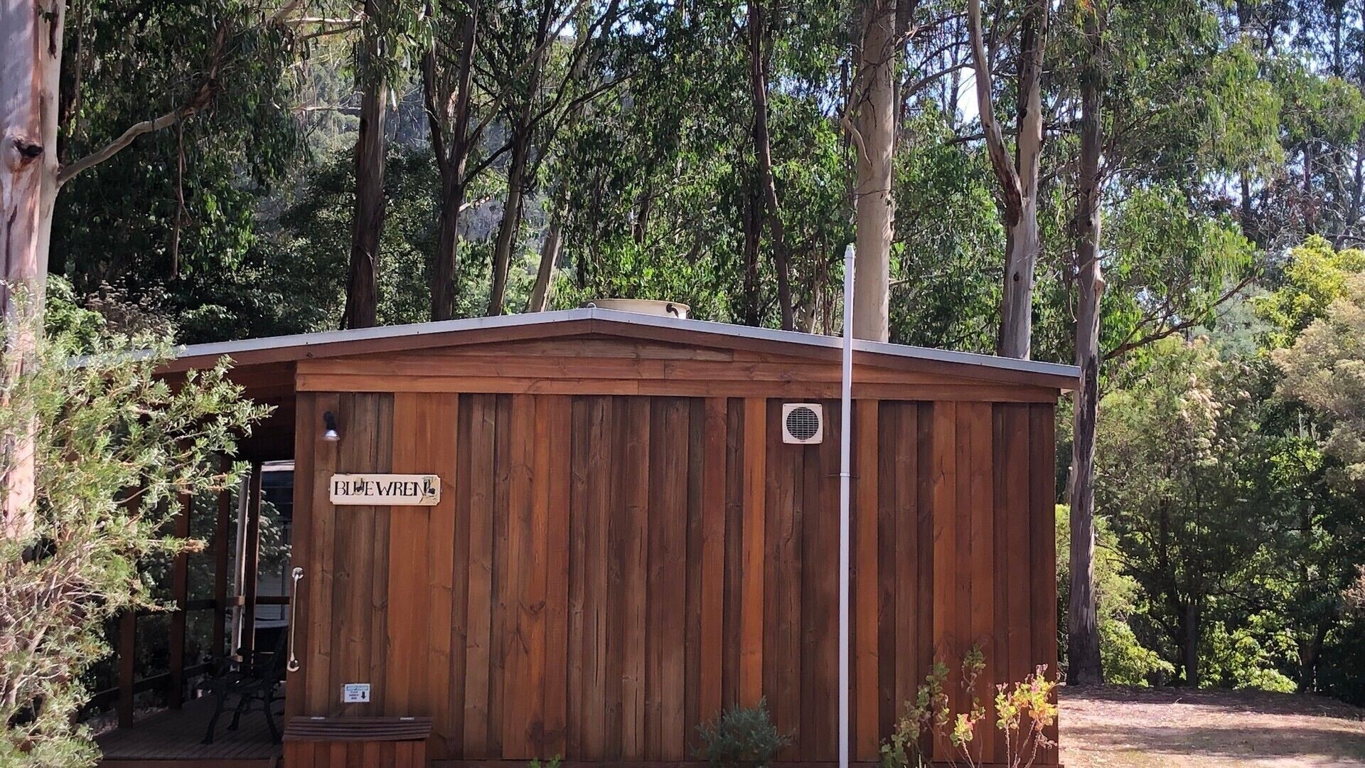 A wooden cabin with a sign reading "BLUE WREN".
