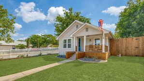 A single-story house with a front porch, a small deck, and a wooden fence. - StockYards! Less than 4 minutes-Sleeps 8-Lee House, TCU close by (Fort Worth)