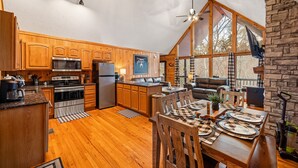 Cozinha espaçosa com armários de madeira, uma ilha grande e um espaço de refeições com jogos americanos xadrez.