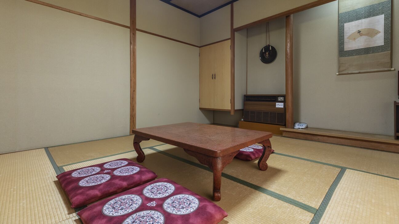 Een traditionele Japanse kamer met tatami vloerbedekking, een lage houten tafel en een futonbed.