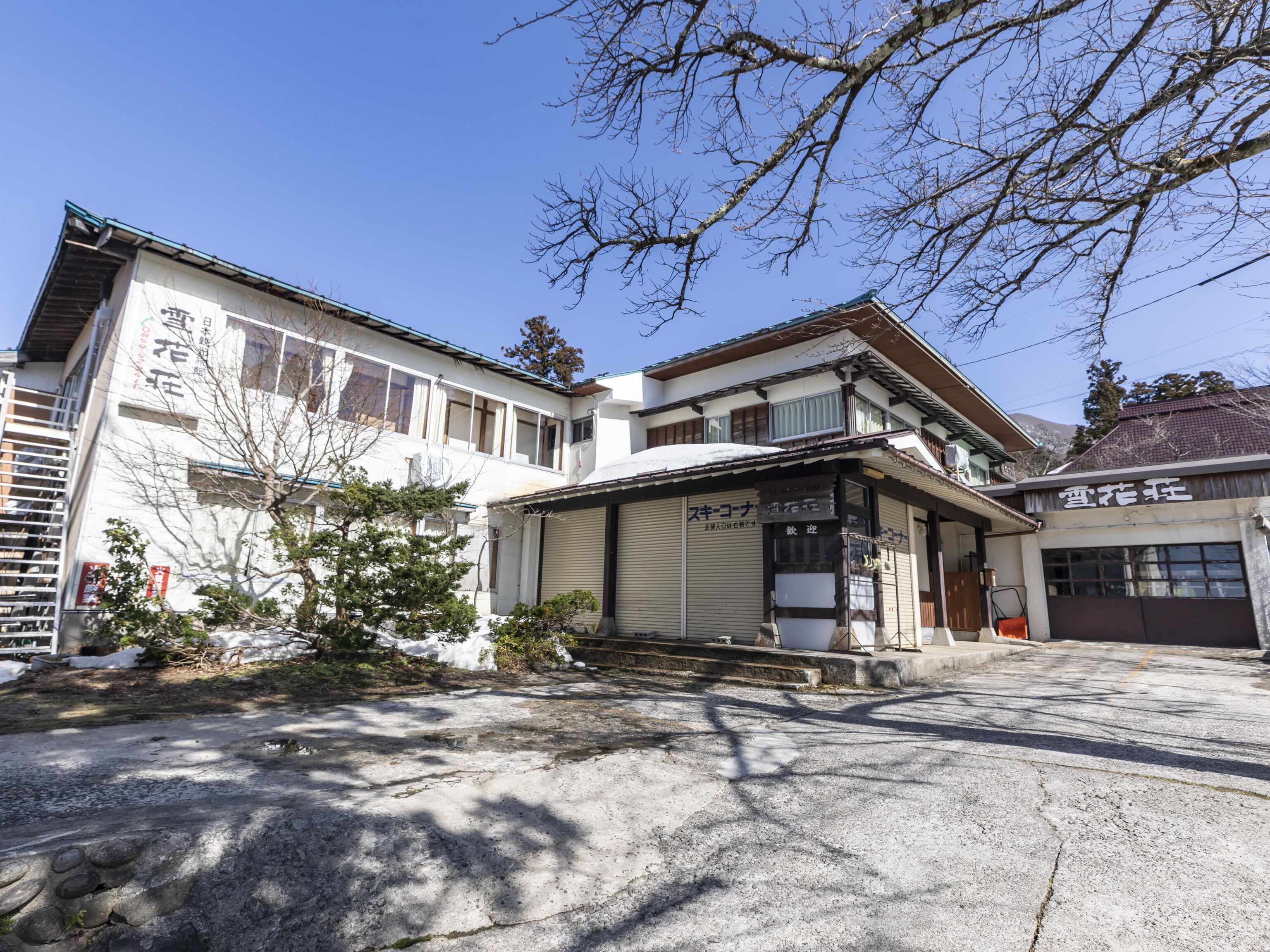 A traditional Japanese building with a large garage and a covered entrance.