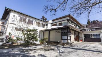 A traditional Japanese building with a large garage and a covered entrance.