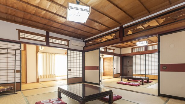 A traditional Japanese room with tatami flooring, sliding doors, and a low table. - Tabist Sekkasou (Daisen)