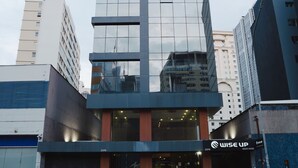 A modern building with a glass facade, a storefront with a sign reading "WISE UP," and a visible address number "2376."