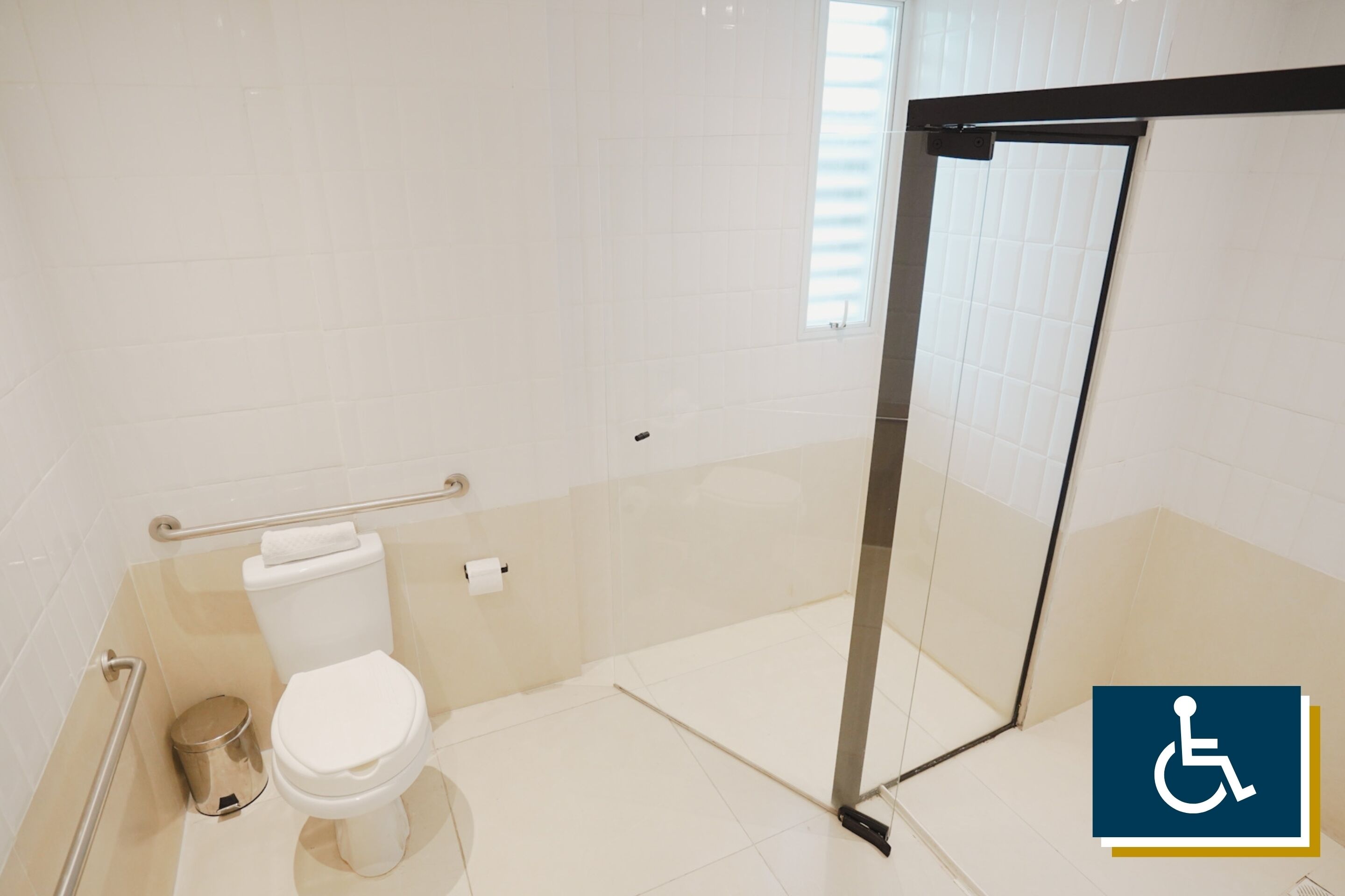 Un baño con inodoro, un bote de basura y un box de ducha de vidrio.