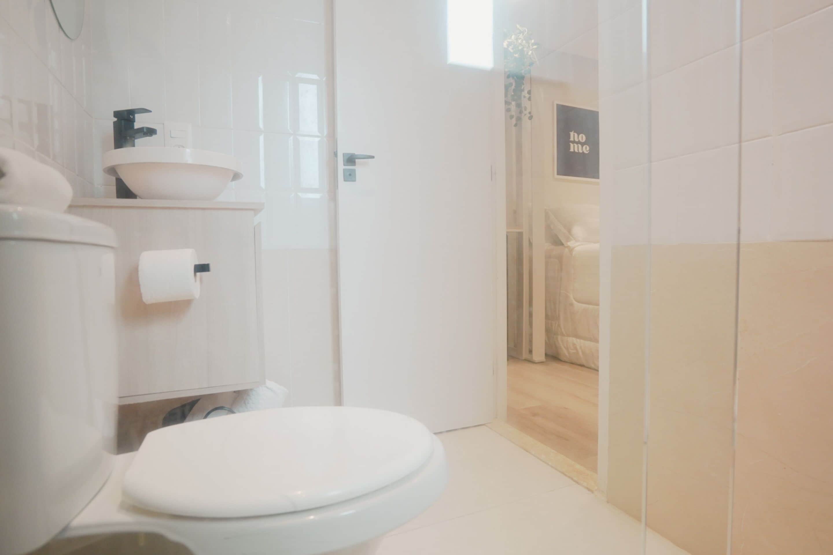 A modern bathroom with a toilet, sink, and shower area.