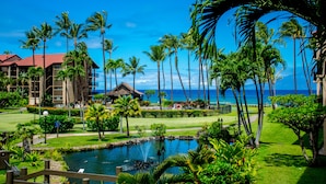 A resort with a pool, palm trees, and a view of the ocean. - Premier Spacious Condo with Stunning Ocean Views (Lahaina)